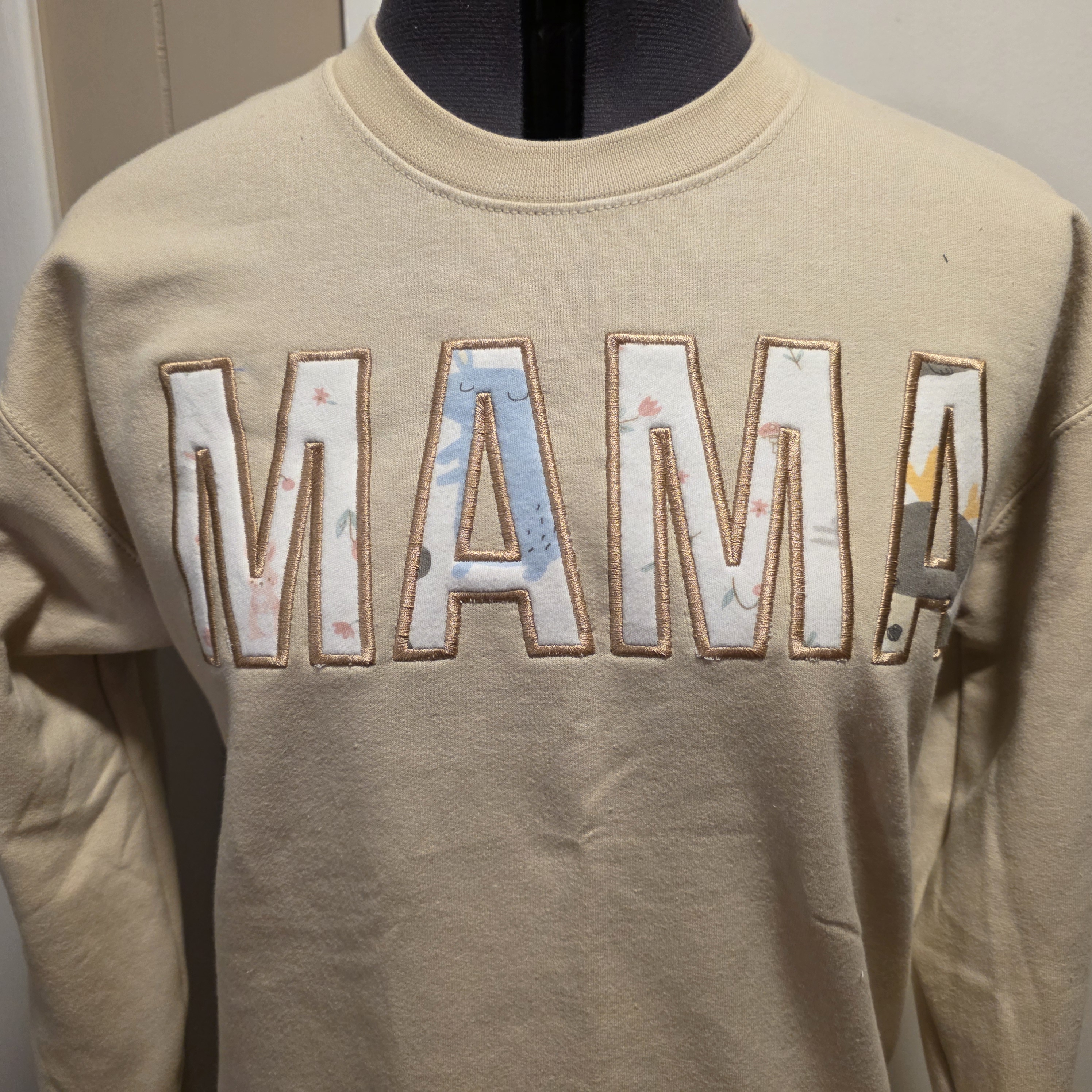 Completed tan crewneck sweatshirt with large MAMA appliqué letters across the chest
