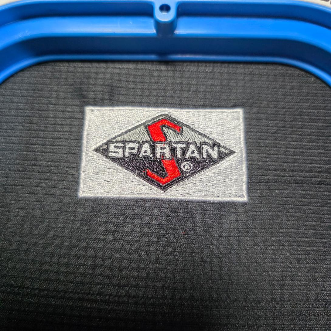 Close-up of completed Spartan logo embroidery on a dark knit garment